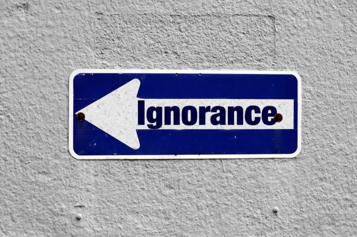 A sign on the wall with an arrow saying 'ignorance'