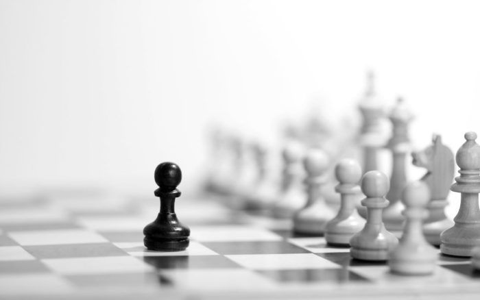 Chess board with a single black pawn